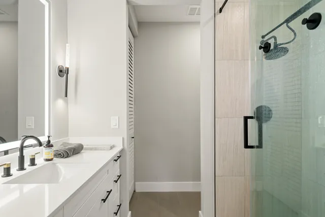 a bathroom with a double vanity sink a mirror and shower