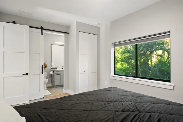 a bedroom with a bed and a large window