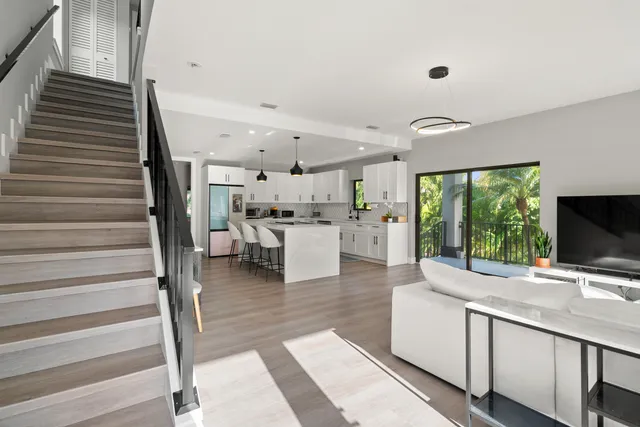 a living room with stainless steel appliances kitchen island granite countertop furniture and a flat screen tv