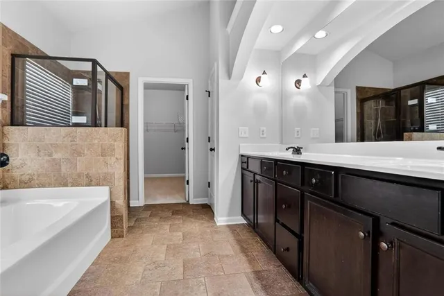 a bathroom with a double vanity sink a mirror and a bathtub