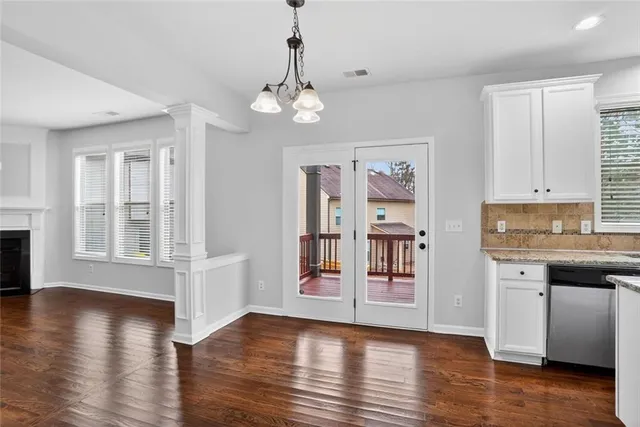 a open kitchen with stainless steel appliances granite countertop a refrigerator a stove cabinets and wooden floor