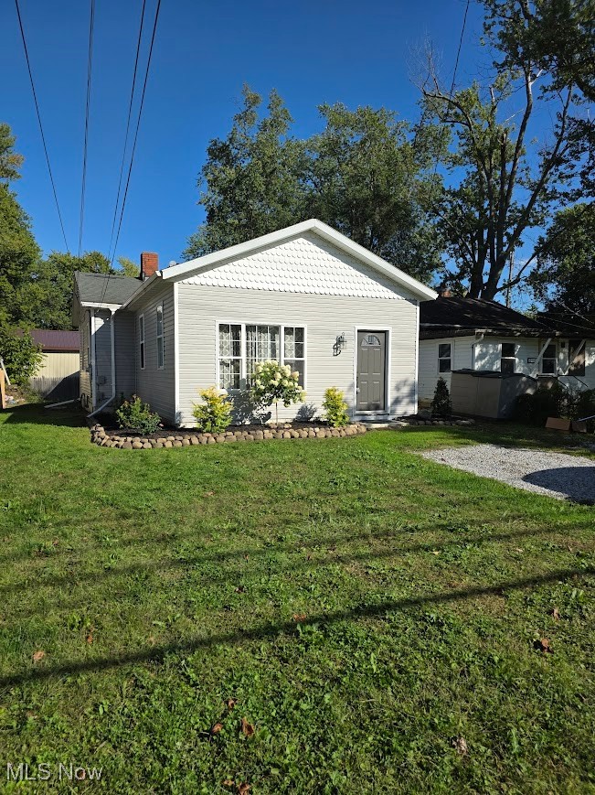 1445 Hubbard Road Madison, OH 44057 - Photo 2 of 21 View of front of house featuring a front yard and a chimney