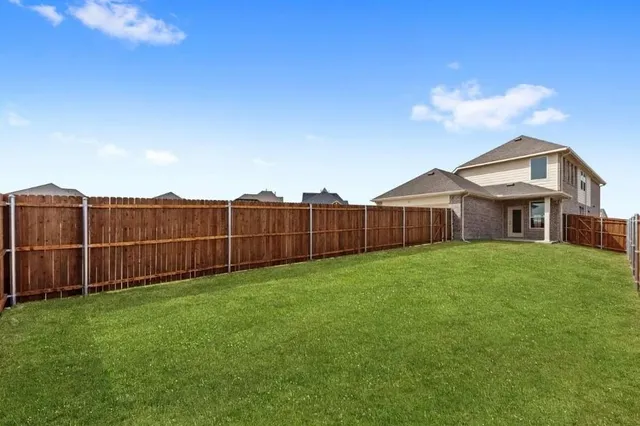 a view of a yard with wooden fence