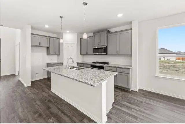 a kitchen with kitchen island a sink stove and refrigerator