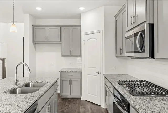 a kitchen with white cabinets sink and stainless steel appliances