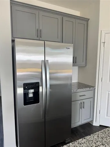 a kitchen with a refrigerator and a stove top oven