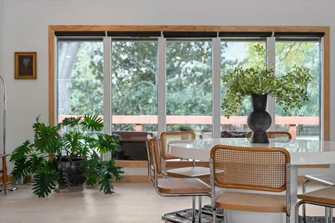 a living room with furniture a flat screen tv and large windows