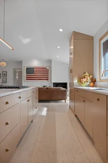 a kitchen with stainless steel appliances a sink a stove a refrigerator and white cabinets with wooden floor