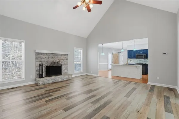 an empty room with kitchen and fireplace