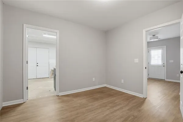an empty room with wooden floor & closet area