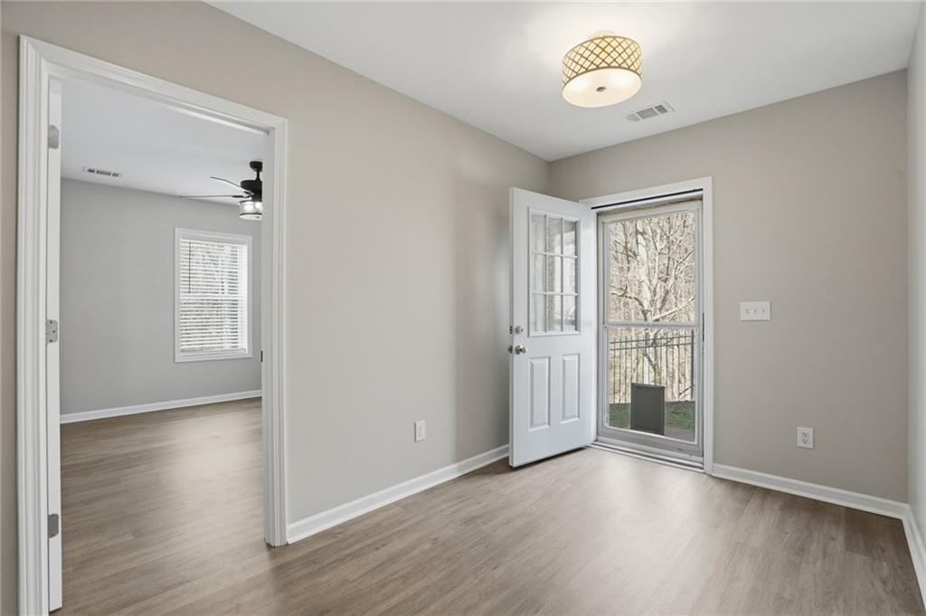 3664 McEver Lake Road Pendergrass, GA 30567 - Photo 30 of 39 an empty room with wooden floor and windows