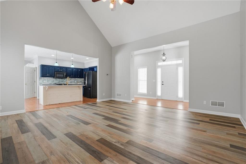 3664 McEver Lake Road Pendergrass, GA 30567 - Photo 4 of 39 an empty room with wooden floor and a kitchen
