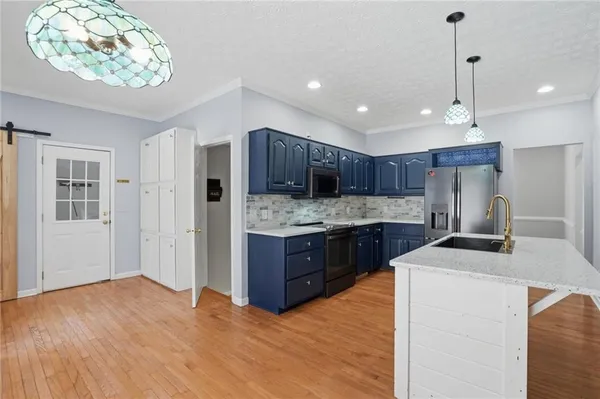 a kitchen with stainless steel appliances granite countertop a sink refrigerator and cabinets