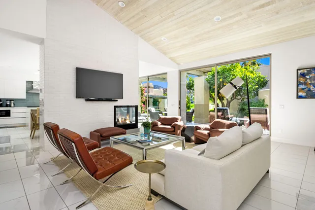a living room with furniture a flat screen tv and a large window