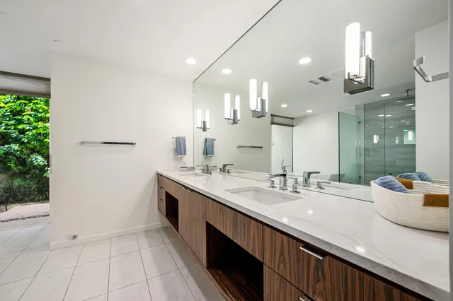 a bathroom with a double vanity sink mirror and shower