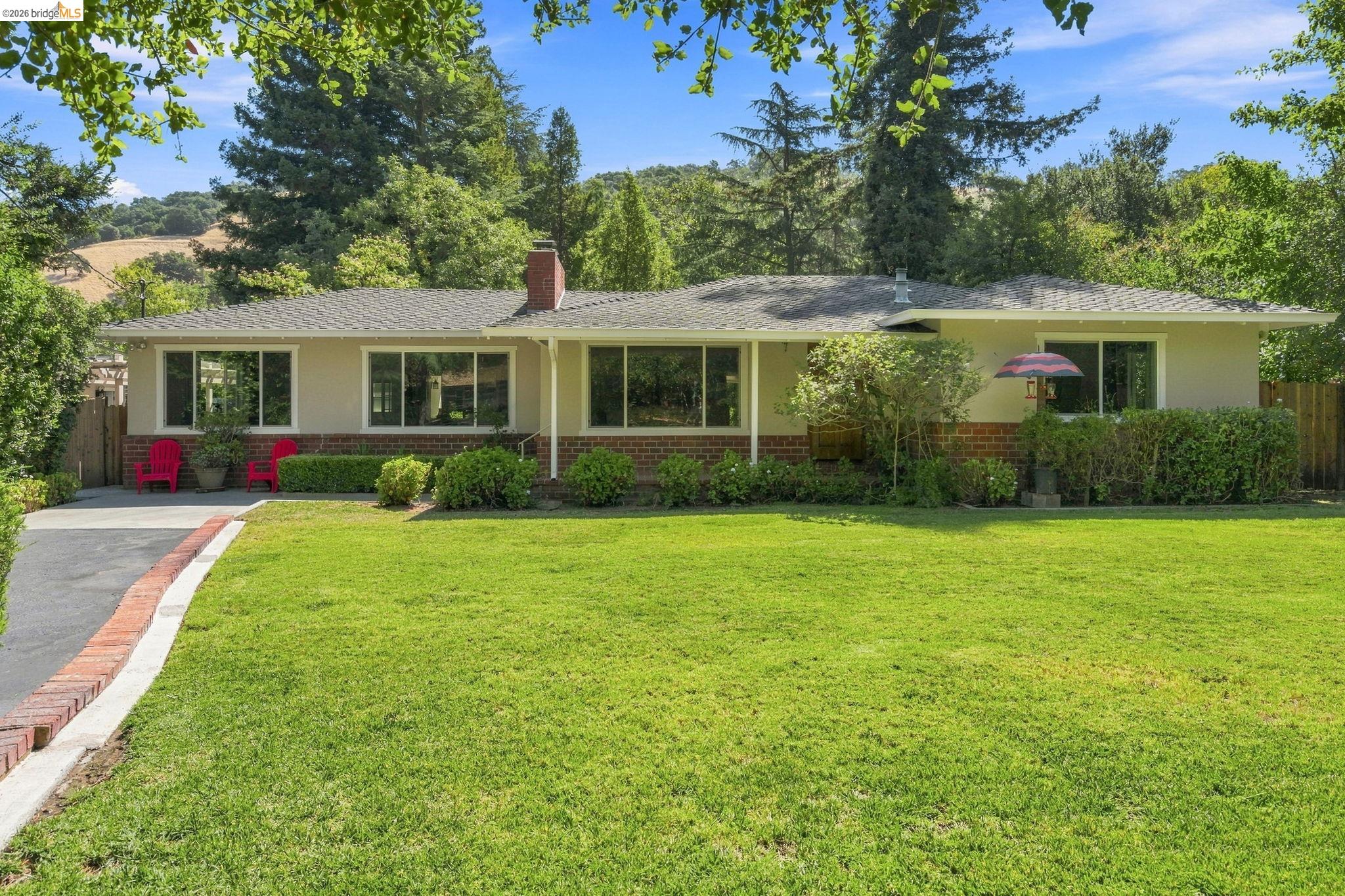 5075 Alhambra Valley Road Martinez, CA 94553 - Photo 1 of 68 Ranch-style exterior with a brick skirt and chimney, a wide front lawn, and mature landscaping