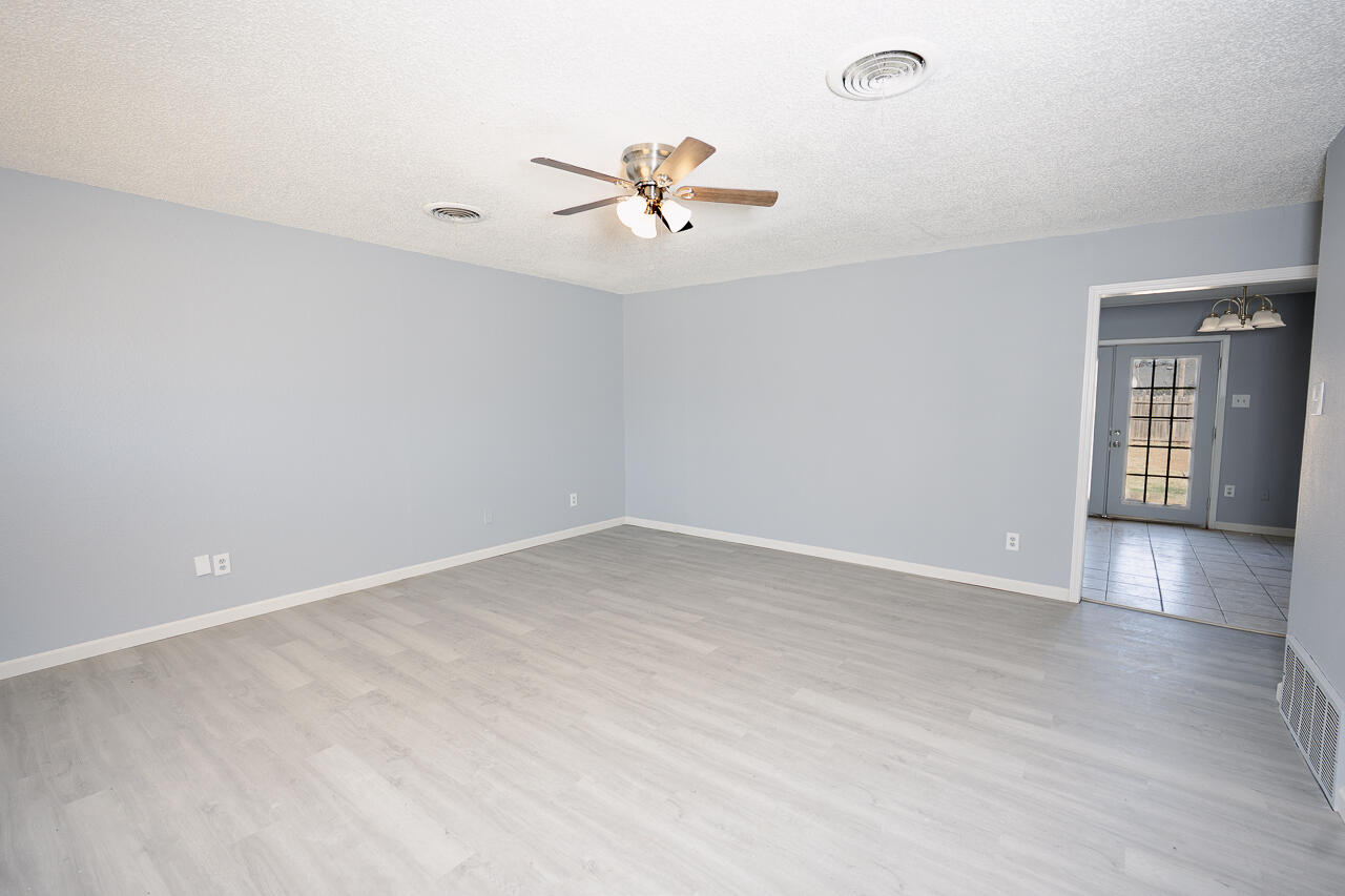 2802 40th Street Lubbock, TX 79413 - Photo 7 of 21 wooden floor in an empty room with a window