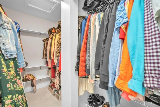 a view of walk in closet with clothes and shoes