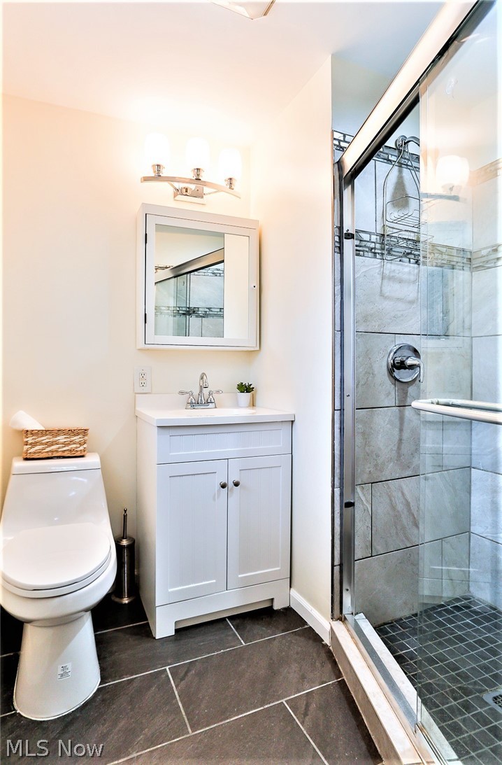 3586 Oak Road Stow, OH 44224 - Photo 22 of 34 *LUXURIOUS MASTER BATHROOM W/SLATE GREY TILED FLOOR, WHITE VANITY, SINK AND MEDICINE CABINET, DUAL FLUSH COMFORT HEIGHT TOILET, FRAMELESS DOORS AND CUSTOM TILED SHOWER!! ~