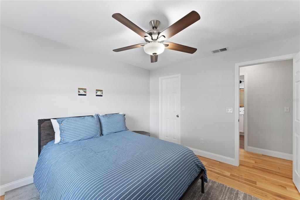 909 Bentwood Lane, Unit 1 Port Orange, FL 32127 - Photo 12 of 36 a bedroom with a bed and a ceiling fan