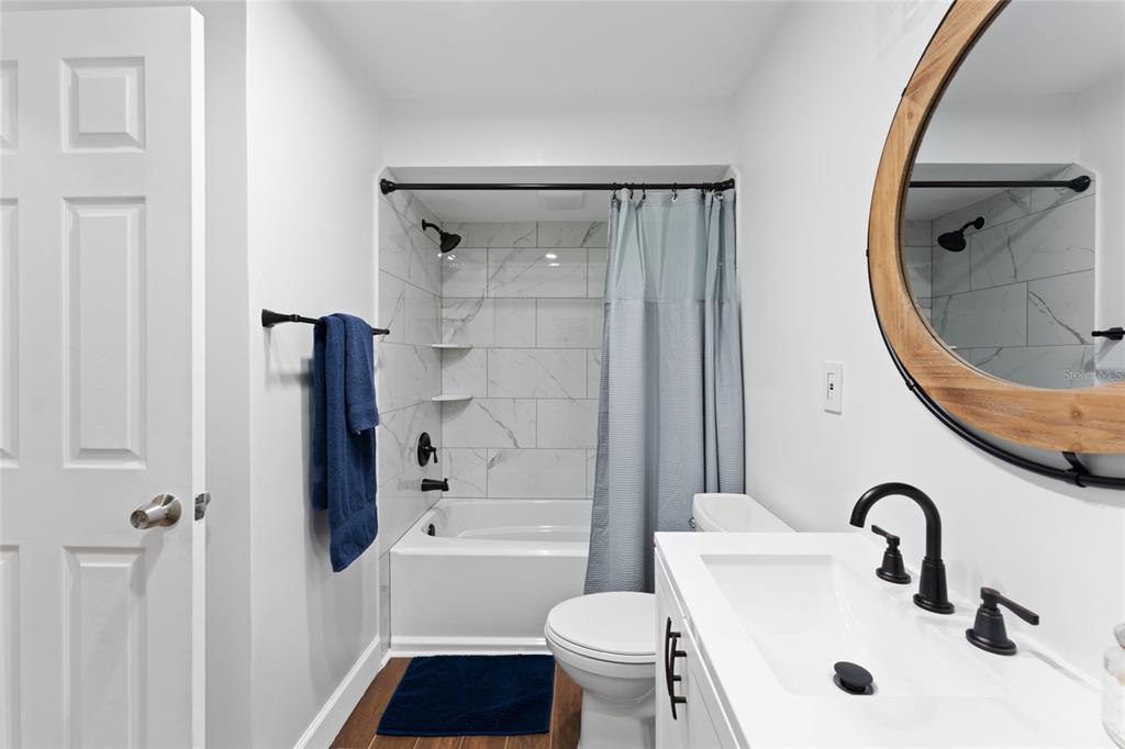 909 Bentwood Lane, Unit 1 Port Orange, FL 32127 - Photo 15 of 36 a bathroom with a sink toilet and shower