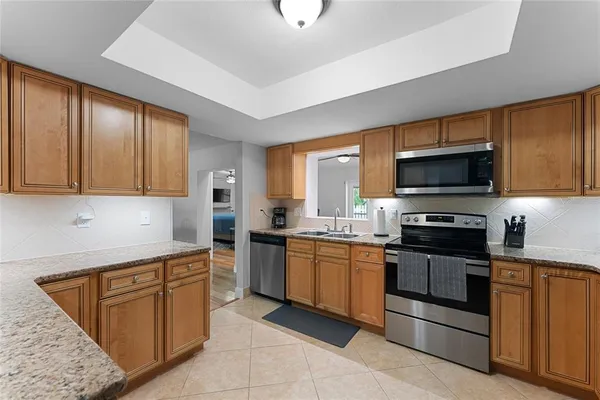 a kitchen with stainless steel appliances granite countertop a stove top oven a sink dishwasher and a microwave oven on the blue kitchen countertops