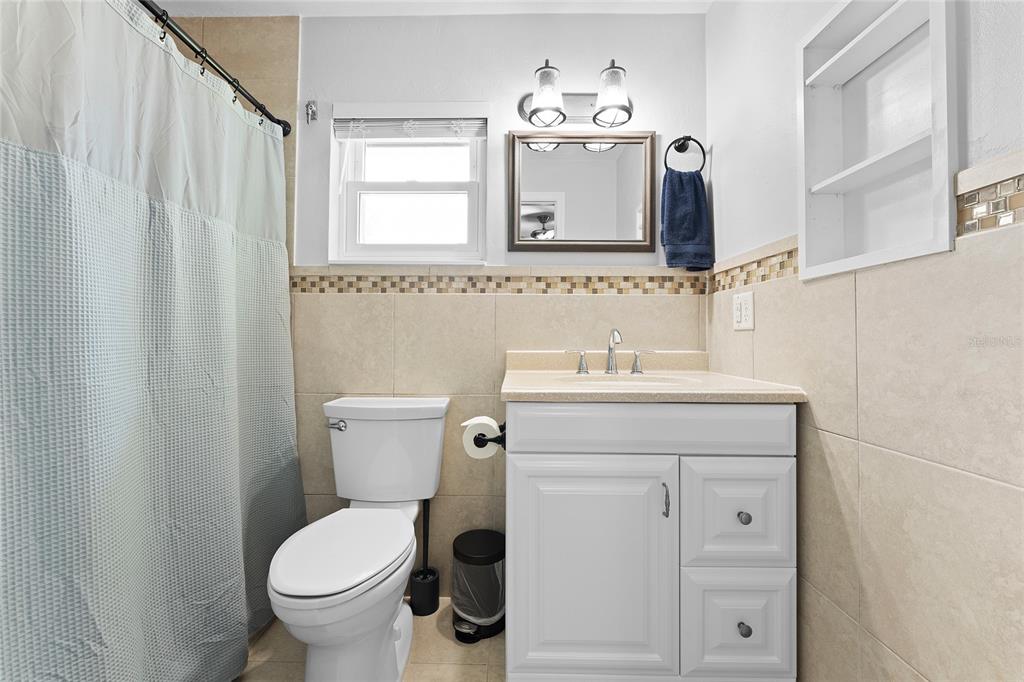 909 Bentwood Lane, Unit 1 Port Orange, FL 32127 - Photo 25 of 36 a bathroom with a toilet sink and mirror