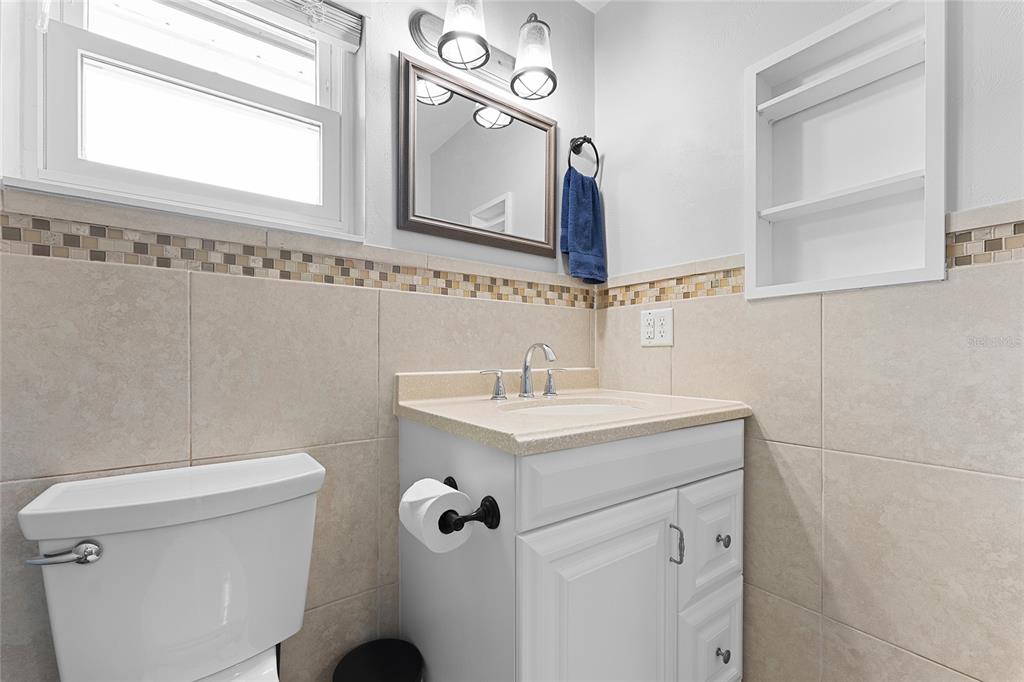 909 Bentwood Lane, Unit 1 Port Orange, FL 32127 - Photo 26 of 36 a bathroom with a sink a mirror and a toilet