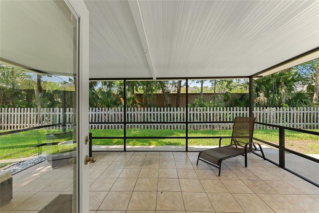 909 Bentwood Lane, Unit 1 Port Orange, FL 32127 - Photo 29 of 36 a view of a chair and floor to ceiling window