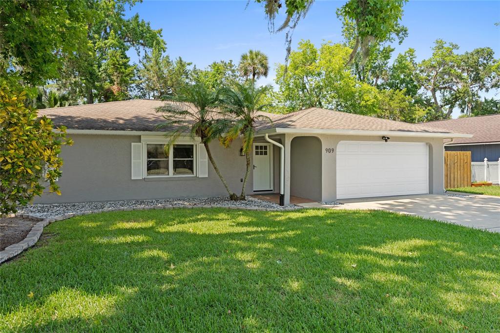 909 Bentwood Lane, Unit 1 Port Orange, FL 32127 - Photo 33 of 36 a front view of a house with a garden