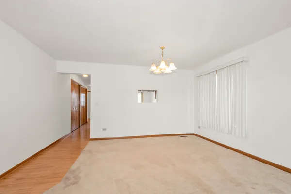 an empty room with chandelier fan