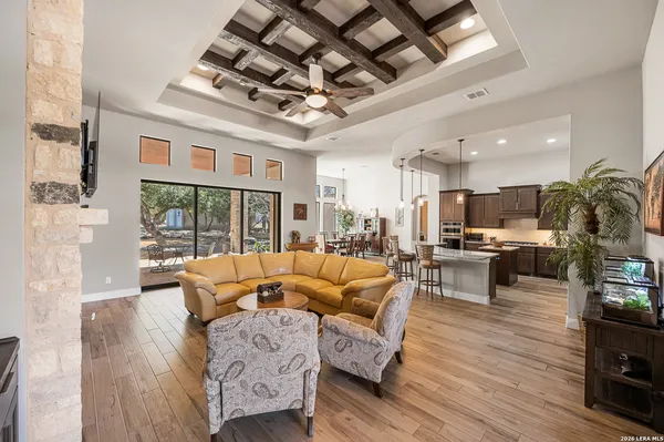 a kitchen with stainless steel appliances kitchen island granite countertop a refrigerator a stove a sink a dining table and chairs with wooden floor