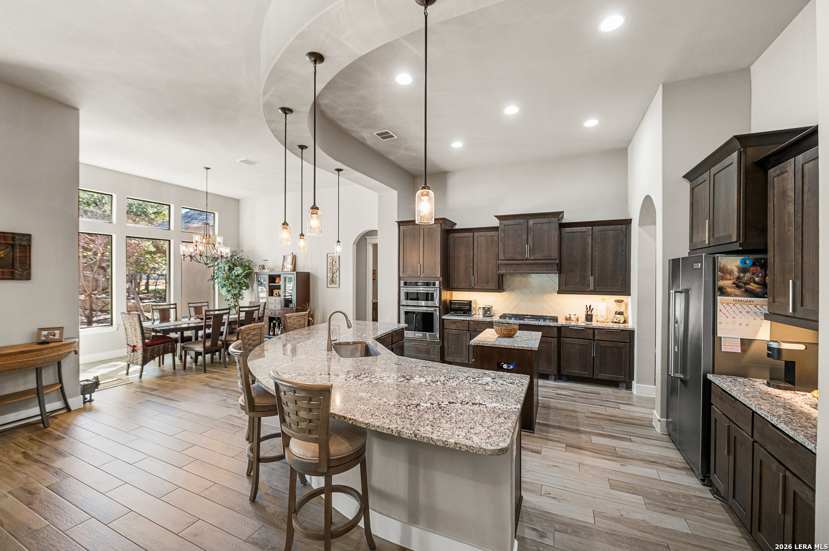 407 Havasu Spring Branch, TX 78070 - Photo 18 of 70 a kitchen with stainless steel appliances kitchen island granite countertop a refrigerator a stove a sink a dining table and chairs with wooden floor