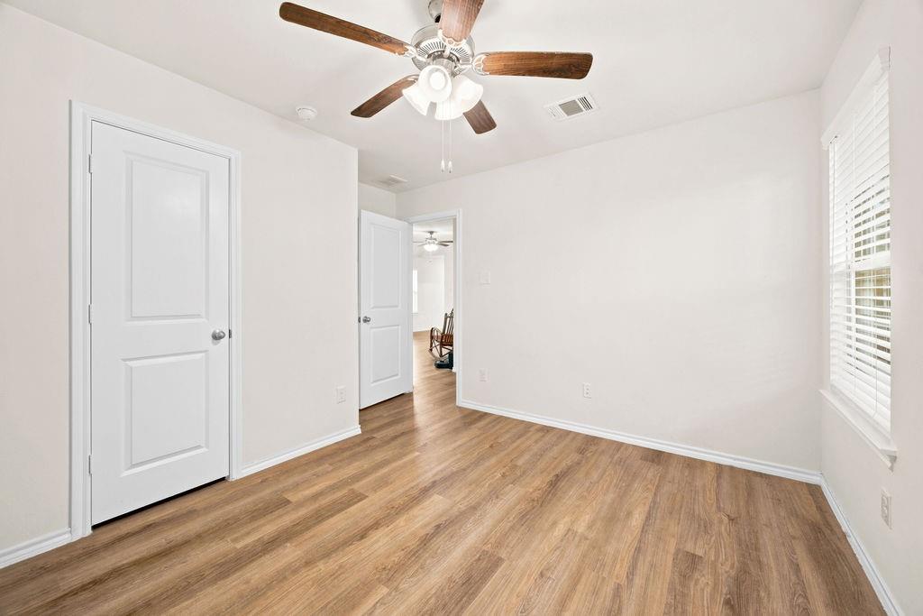 822 Ramble Road Lavon, TX 75166 - Photo 22 of 35 Room featuring wood-finish flooring, white walls, and a ceiling fan with wood-tone blades