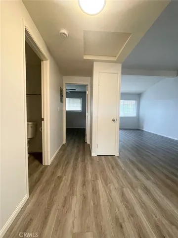 a view of a room with wooden floor and a ceiling fan