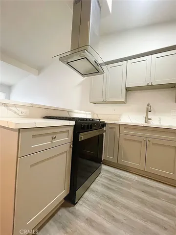 a kitchen with cabinets appliances and wooden floor
