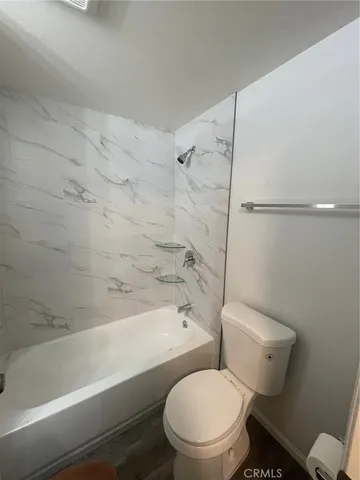a white toilet and tub sitting next to a bathroom sink