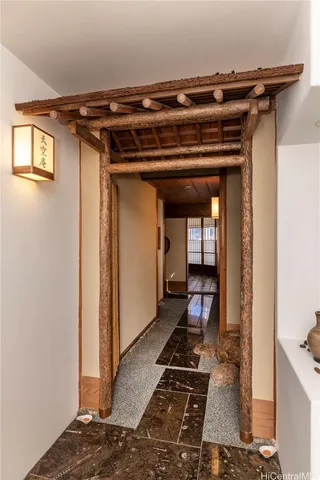 a view of a hallway with wooden floor and a living room