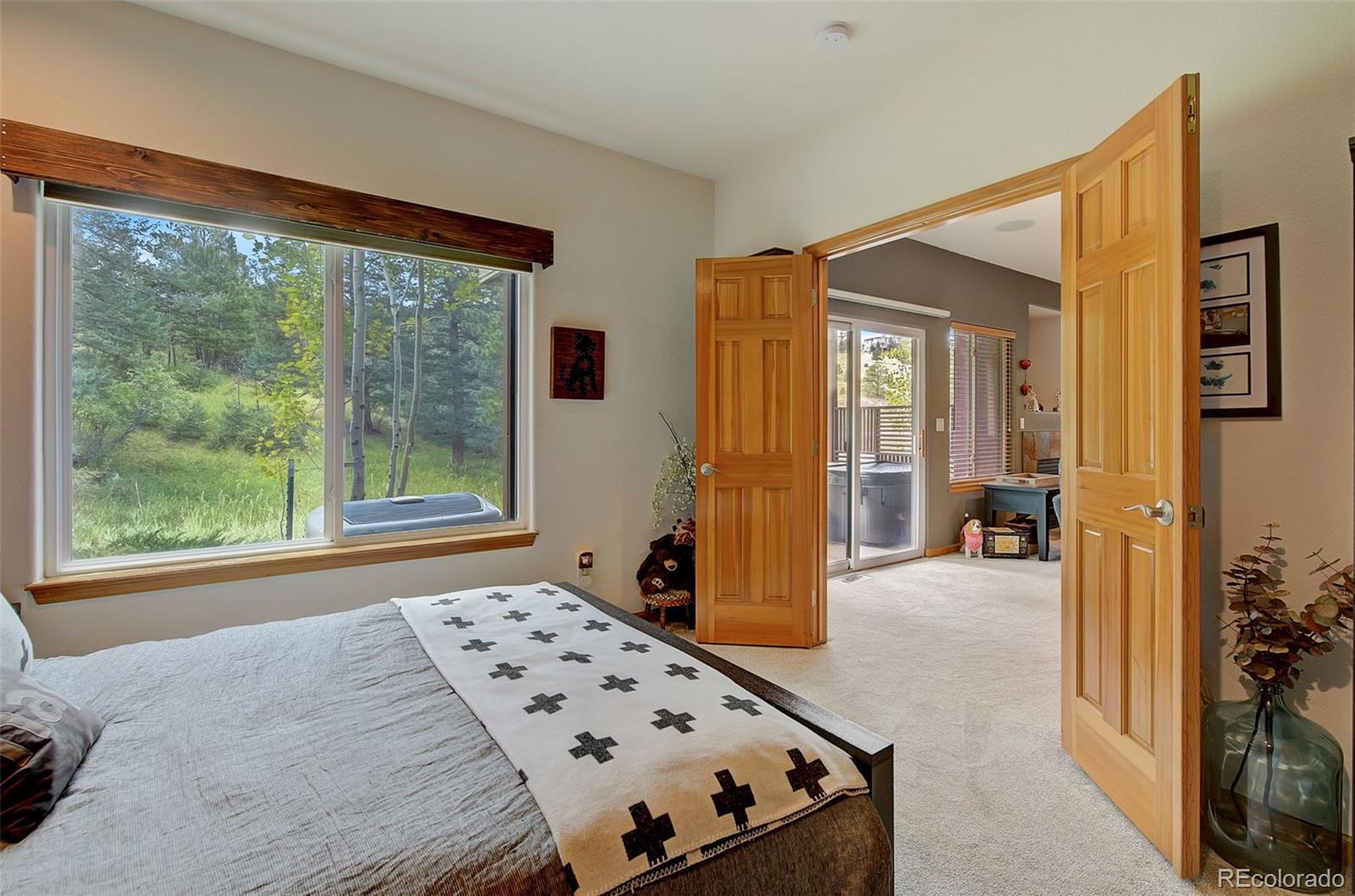 665 Trailside Drive Golden, CO 80401 - Photo 17 of 40 a bedroom with a bed and large windows