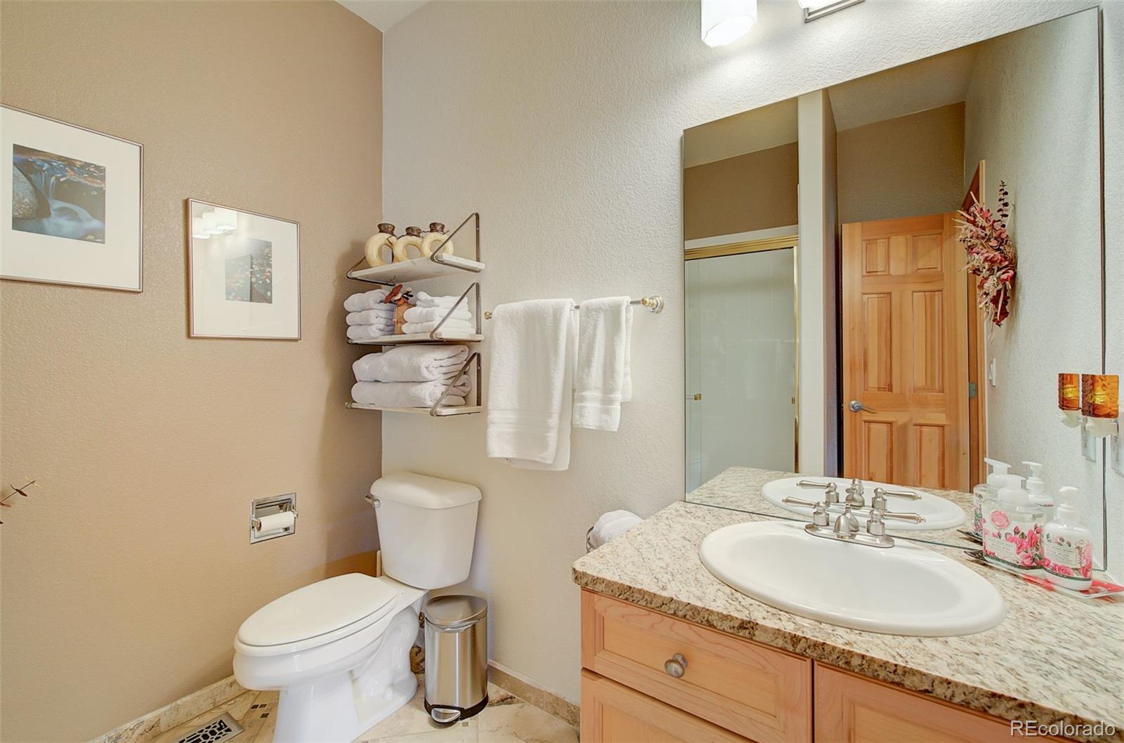 665 Trailside Drive Golden, CO 80401 - Photo 18 of 40 a bathroom with a granite countertop sink mirror vanity and toilet