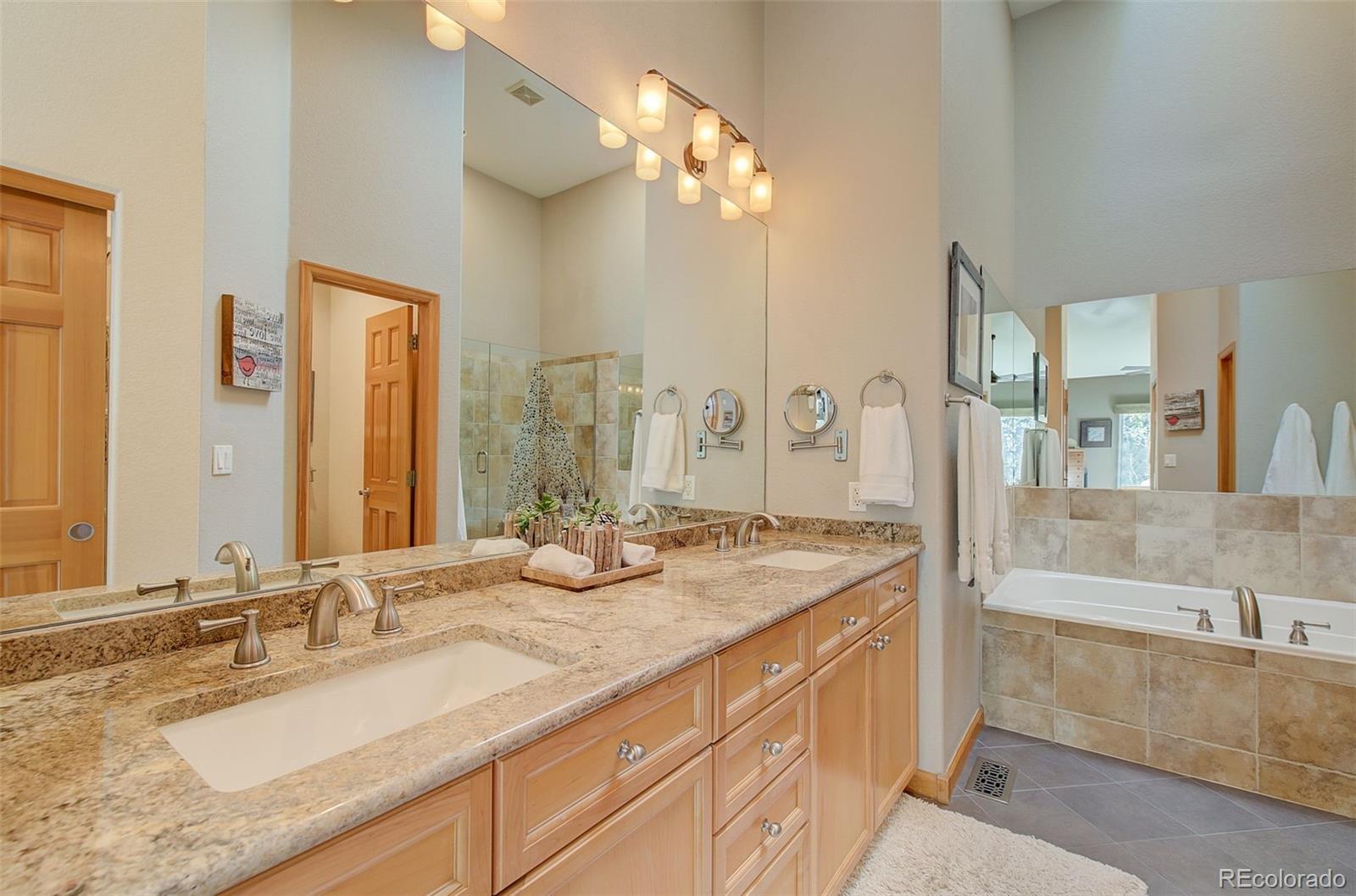 665 Trailside Drive Golden, CO 80401 - Photo 22 of 40 a bathroom with a granite countertop sink and a large mirror
