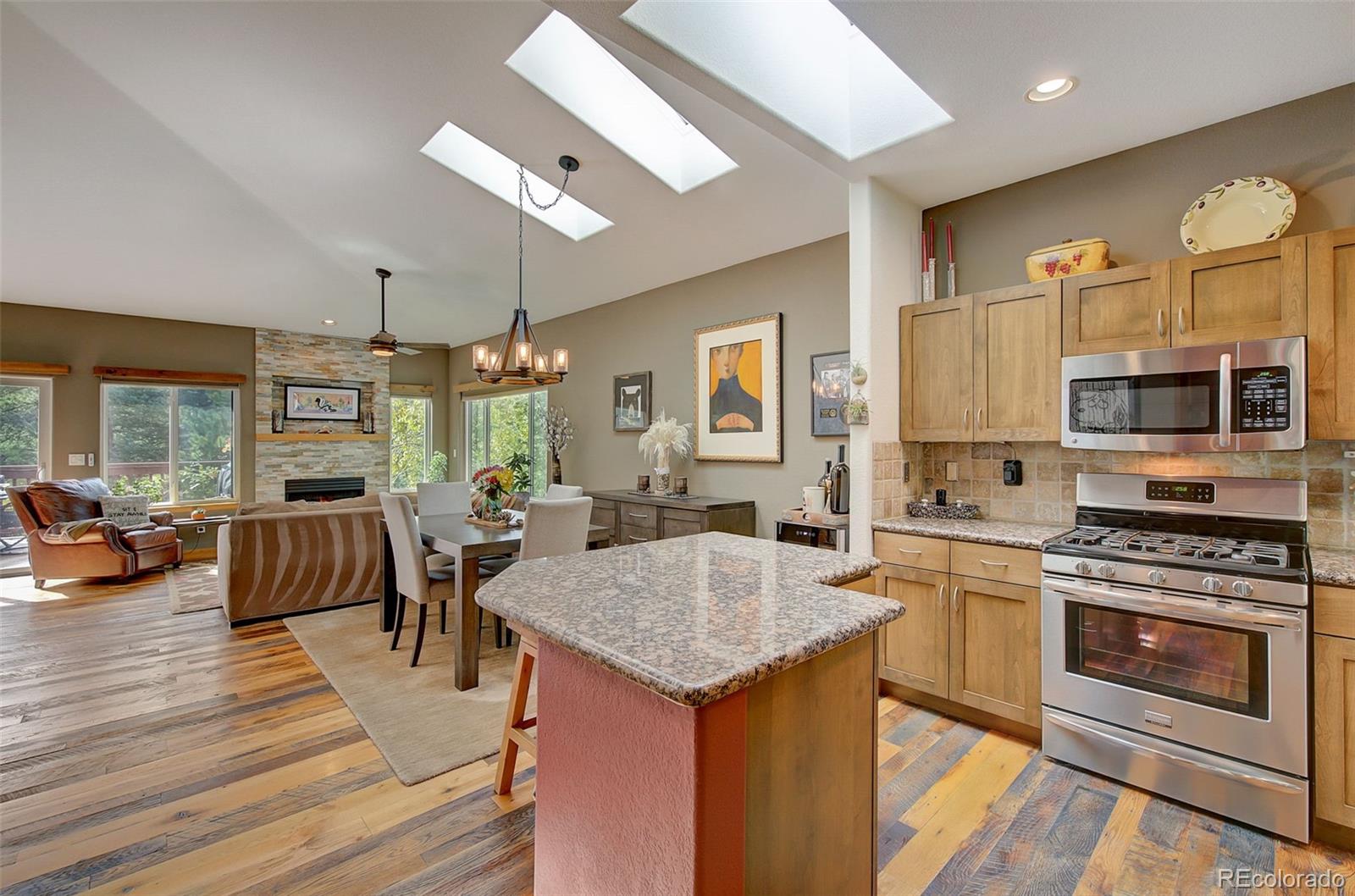 665 Trailside Drive Golden, CO 80401 - Photo 6 of 40 a kitchen with stainless steel appliances granite countertop a stove top oven a sink dishwasher a dining table and chairs with wooden floor