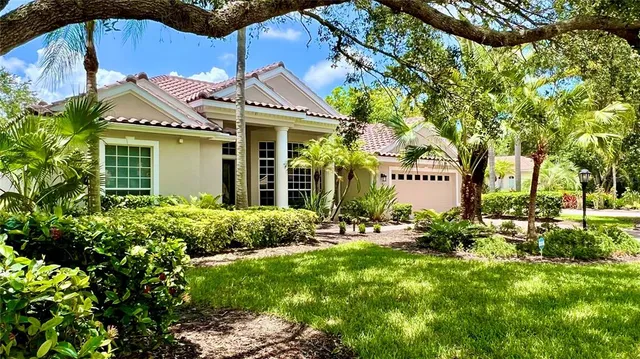 a front view of a house with a yard and potted plants