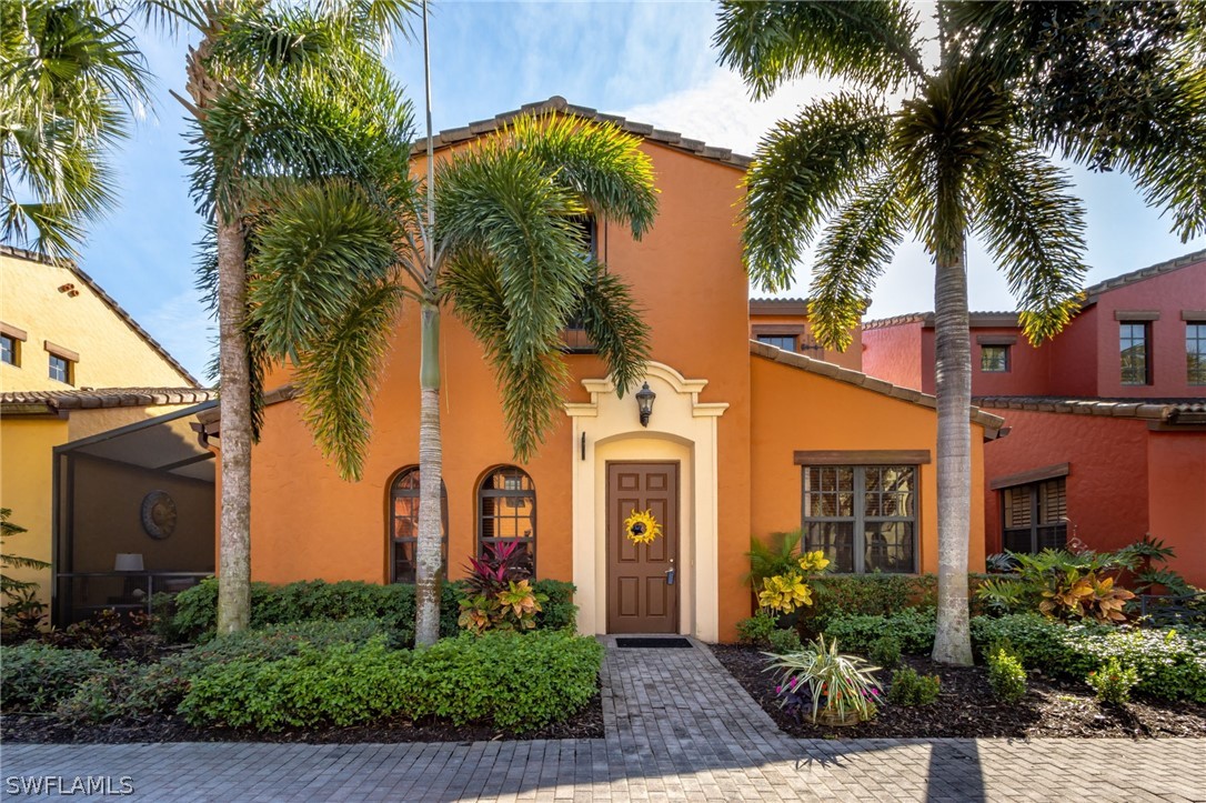 front view of a house with a yard and palm trees