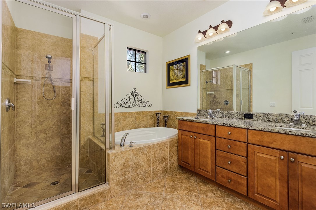 11947 Tulio Way, Unit 4002 Fort Myers, FL 33912 - Photo 13 of 26 a spacious bathroom with a granite countertop sink mirror and shower