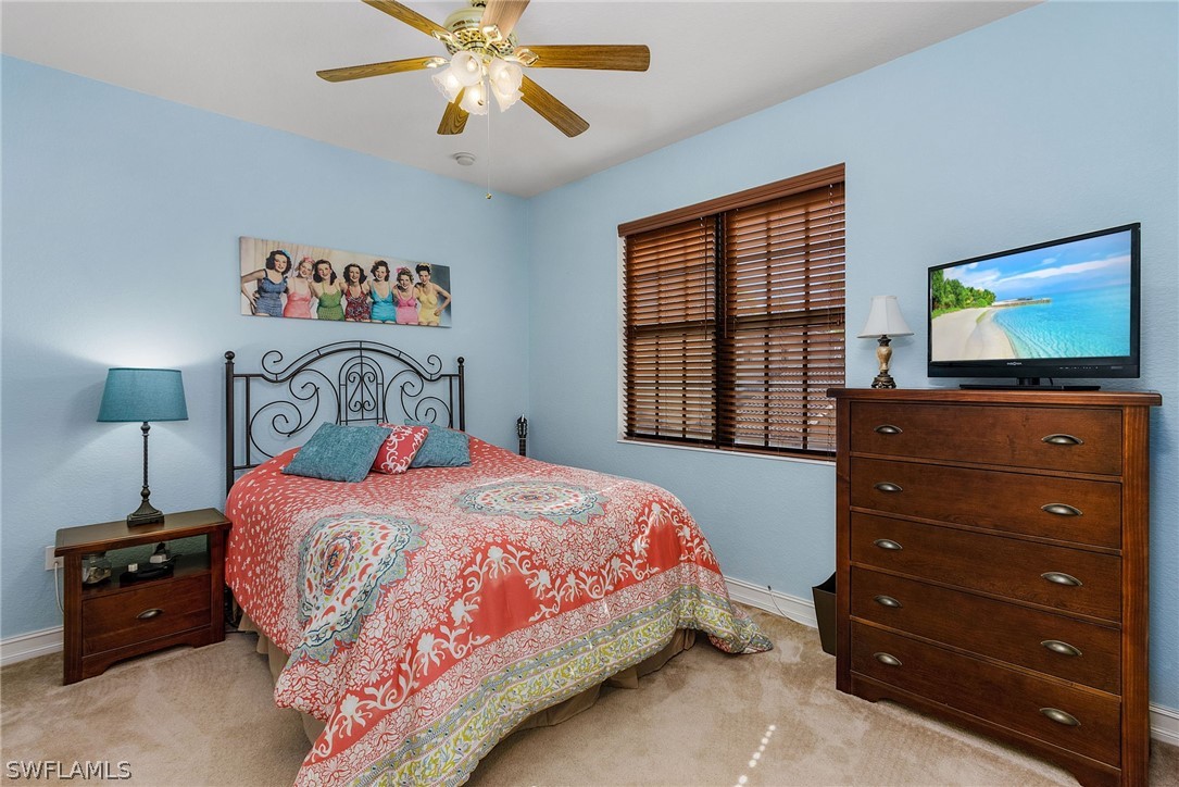 11947 Tulio Way, Unit 4002 Fort Myers, FL 33912 - Photo 14 of 26 a bedroom with a bed and a flat tv screen on dresser