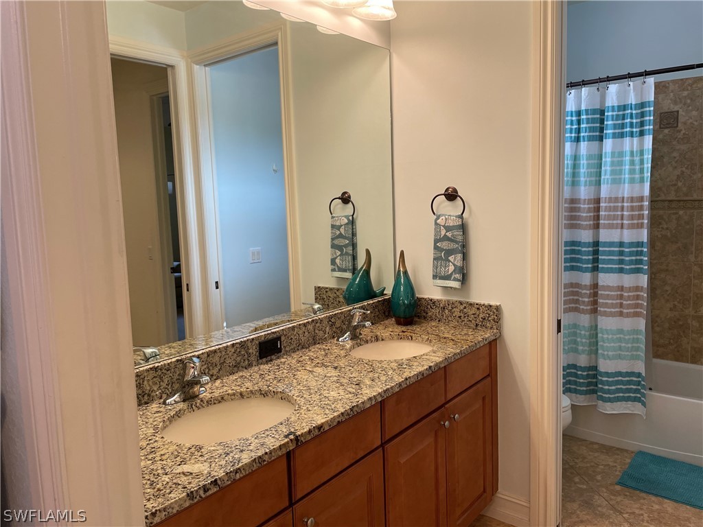 11947 Tulio Way, Unit 4002 Fort Myers, FL 33912 - Photo 15 of 26 a bathroom with a granite countertop sink and a mirror