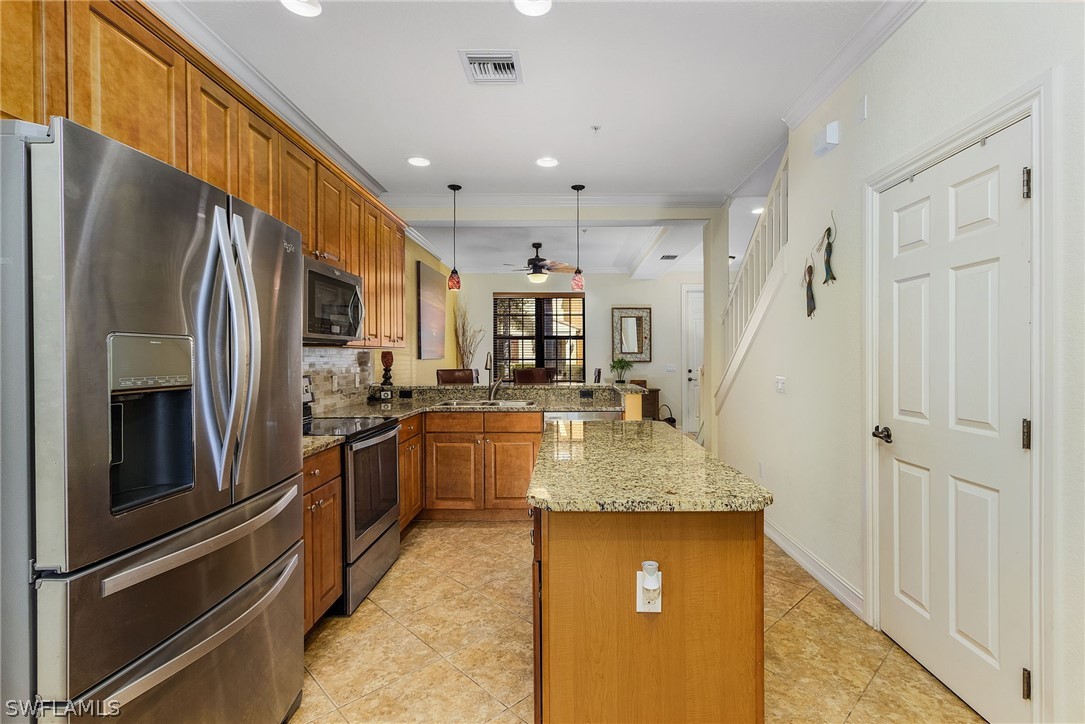 11947 Tulio Way, Unit 4002 Fort Myers, FL 33912 - Photo 5 of 26 a kitchen with stainless steel appliances granite countertop a refrigerator a oven and a sink