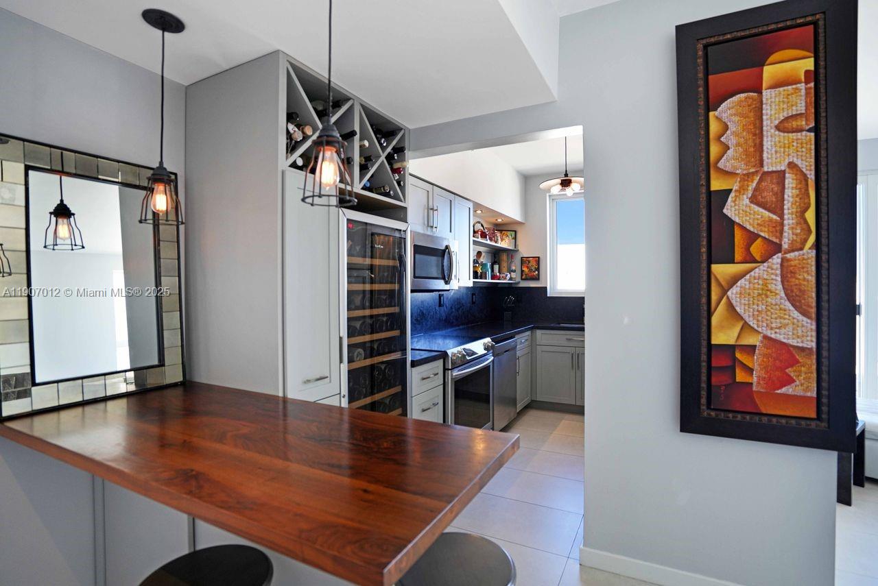 1621 Bay Road, Unit PH1 Miami Beach, FL 33139 - Photo 11 of 32 a kitchen with stainless steel appliances granite countertop a refrigerator and a stove top oven