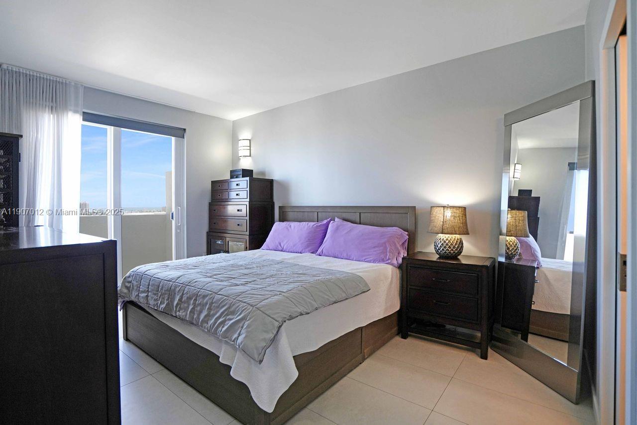 1621 Bay Road, Unit PH1 Miami Beach, FL 33139 - Photo 14 of 32 a bedroom with a bed and wooden floor